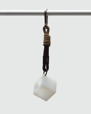 GAMINE HARDWARE Blanc — translucent white cube parfum vessel hanging from knotted tan rope and black strap, suspended from a steel bar. Made for motion, engineered for utility